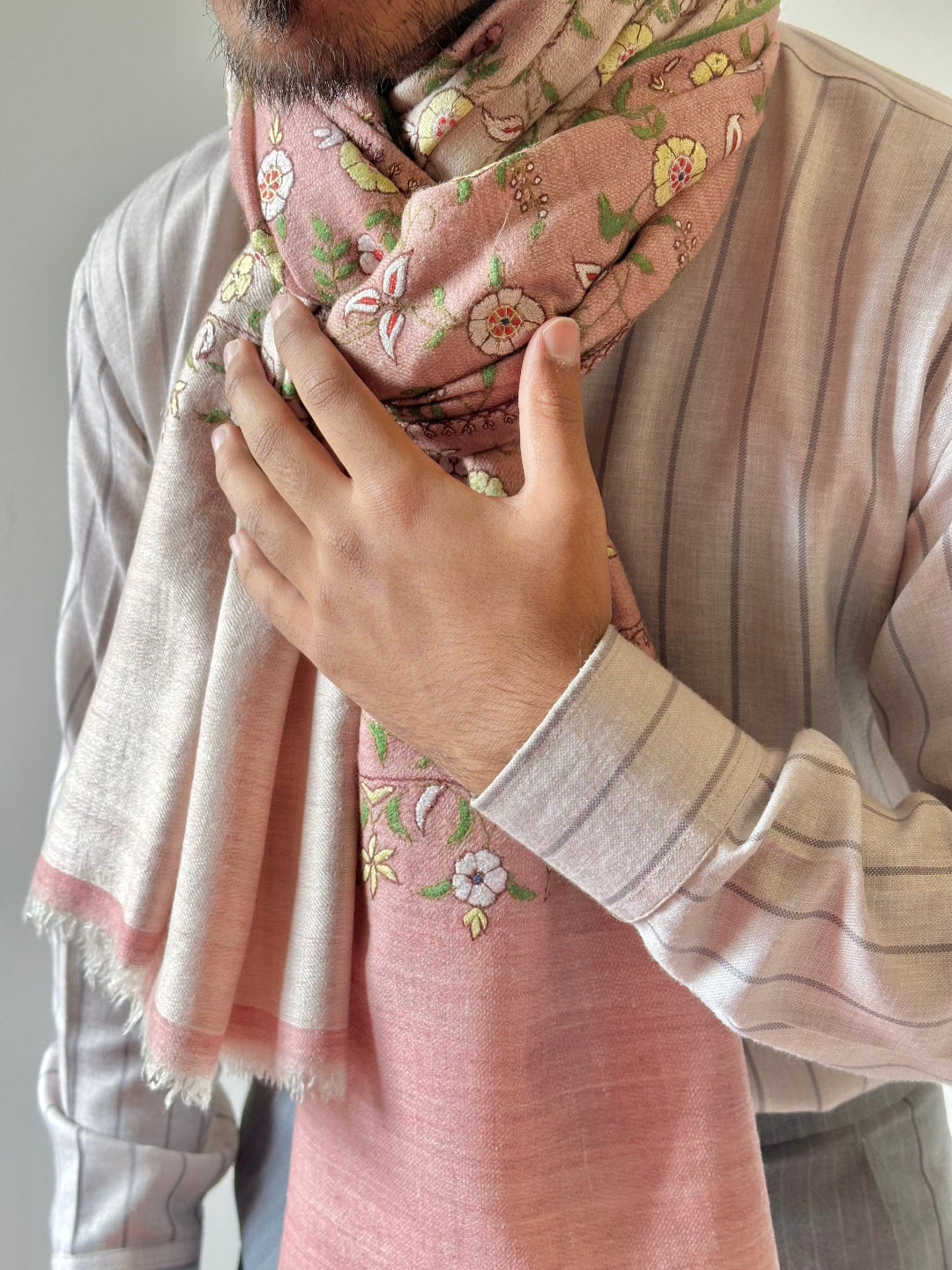 Person wearing a pink floral scarf with a neutral background